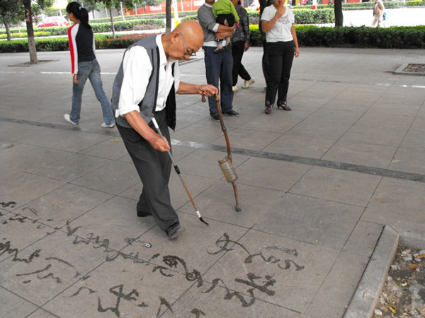 一位老年人在公园写字